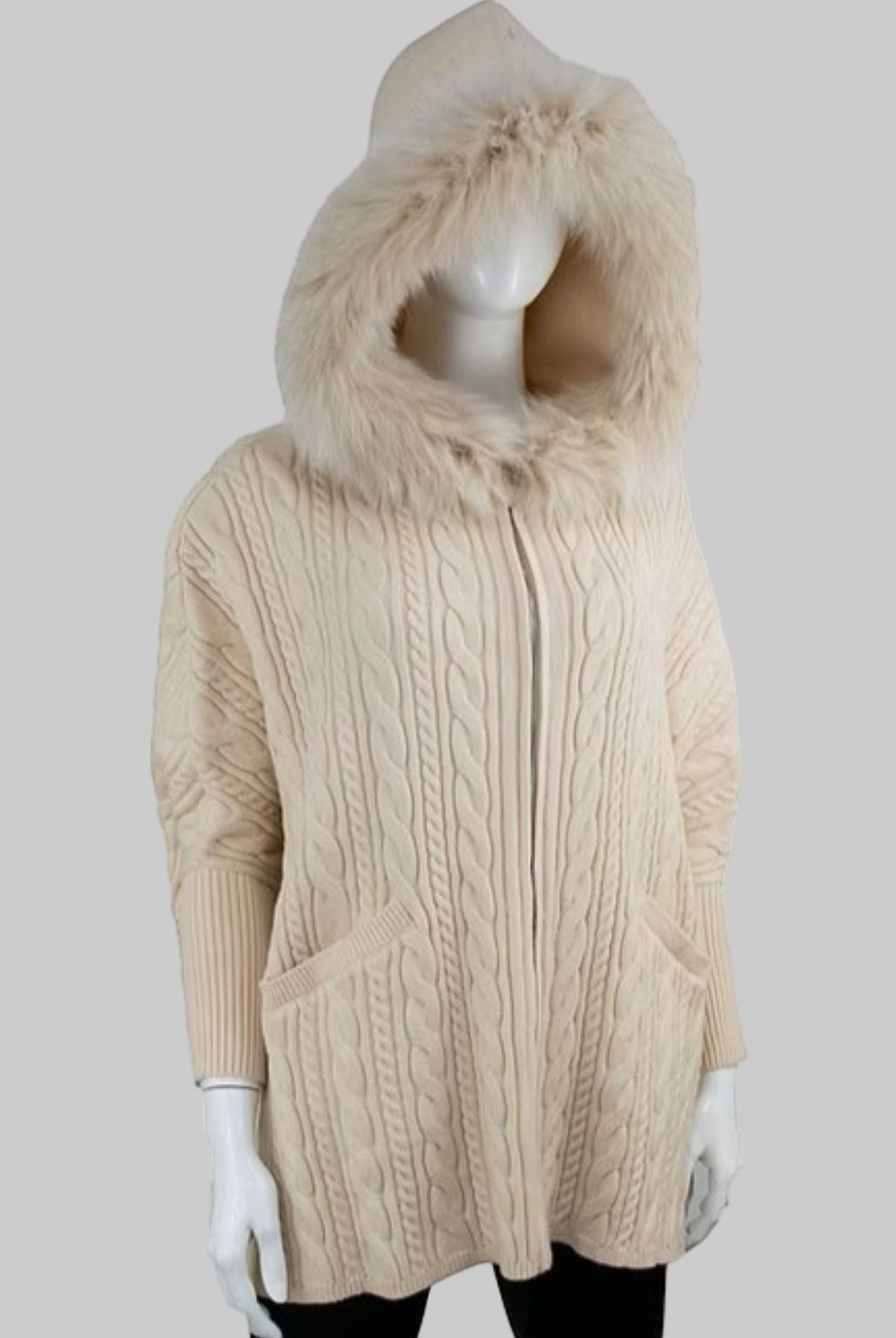 Beige cable knit hoodie with fur hood on a mannequin against a white background