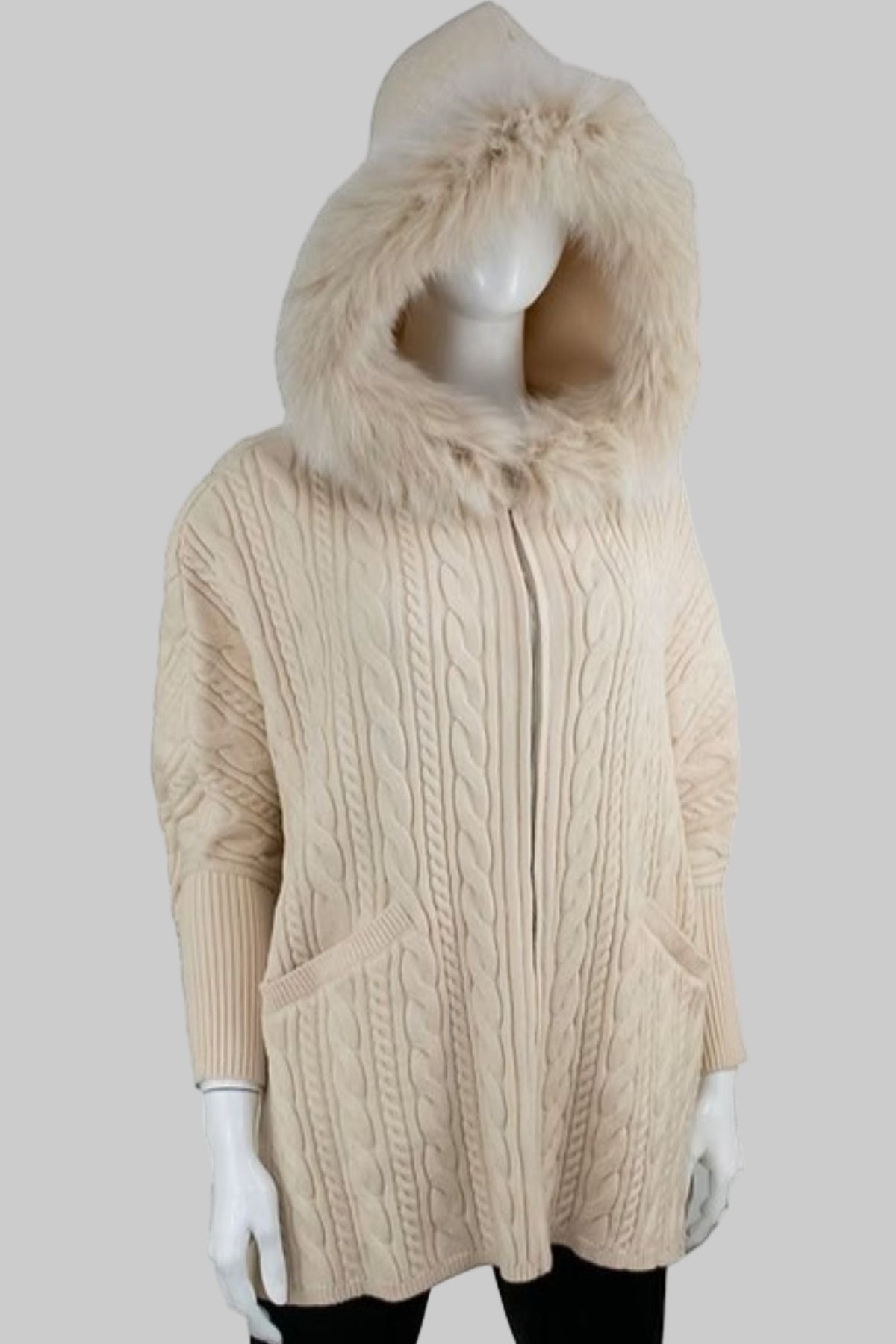 Beige cable knit hoodie with fur hood on a mannequin against a white background